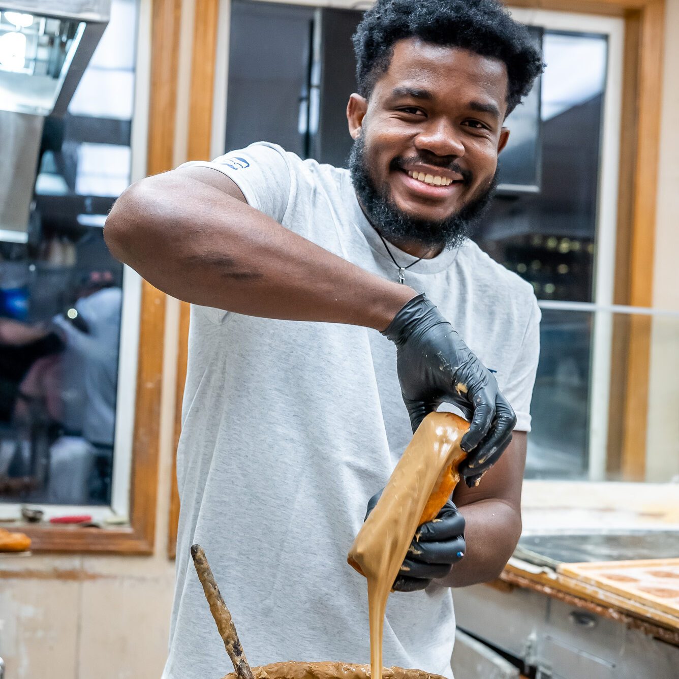 worker icing a maple bar